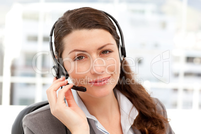 Pretty businesswoman with earpiece and looking at the camera