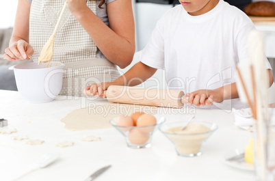 Close up of mother and son preparing a dough together