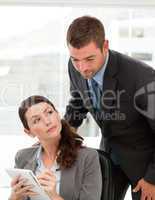 Handsome manager talking with her secretary in the office