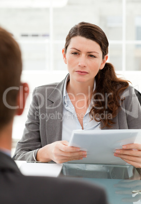 Serious businesswoman questionning a man during a meeting