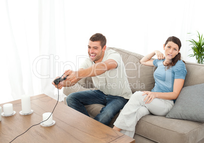 Desperate woman being bored while her boyfriend playing video ga