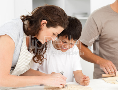 Happy family cooking biscuits together in the kitchen