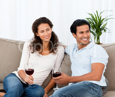 Lovely couple drinking red wine sitting on the sofa