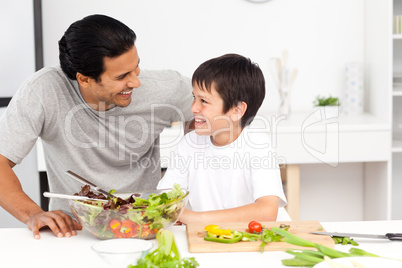 Adorable father and son looking at each other in the kitchen