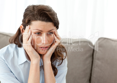 Tired businesswoman having a headache on the sofa