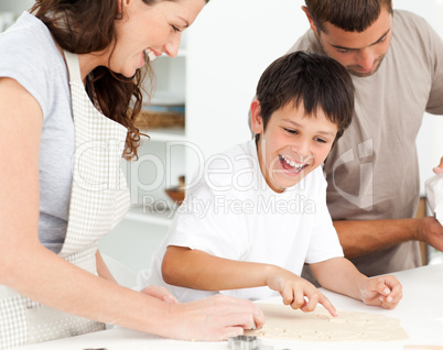 Cheerful family having fun while preparing biscuits together