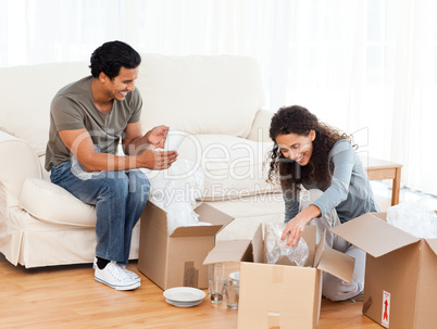 Happy couple packing glasses together in the living-room