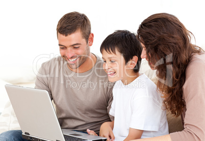 Cute family working on their laptop together sitting on the sofa