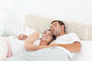 Pensive couple relaxing together lying on the bed