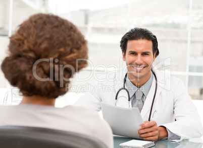 Cheerful hispanic doctor dring an appointment with a patient