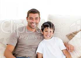 Portrait of adorable father and son sitting on the sofa