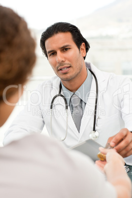 Serious doctor giving pills to his patient during an appointment