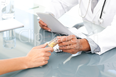 Close up of a doctor giving drugs to his patient during an appoi