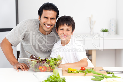 Portrait of a father and his son preparing a salad