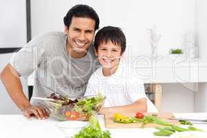 Portrait of a father and his son preparing a salad
