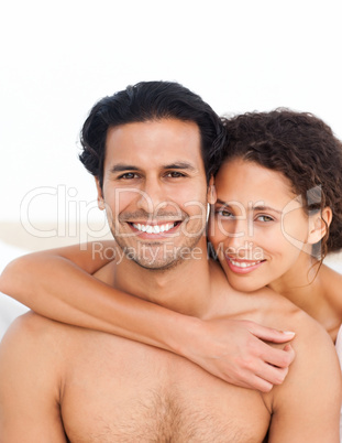Portrait of a hispanic couple sitting  in their bedroom