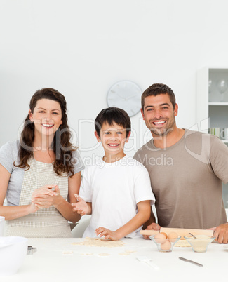 Cute boy with his parents in his kitchen