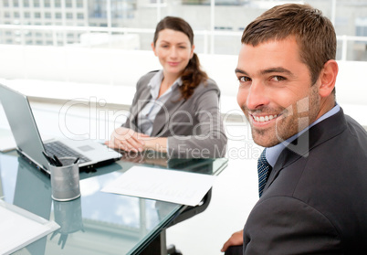 Cheerful business people working on a laptop during a meeting