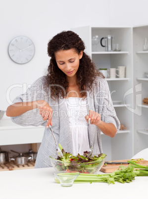 Cute hispanic woman preparing her lunch in the kitchen