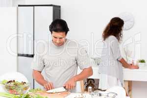 Hispanic couple preparing a salad together in the kitchen