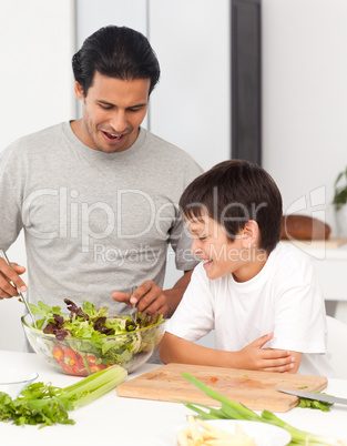 Handsome man preparing a salad with his son