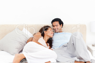 Lovely hispanic couple relaxing in their bedroom