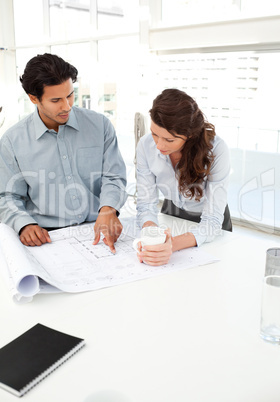 Handsome businessman showing a plan to his beautiful partner