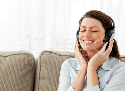 Happy businesswoman relaxing with music in the living-room