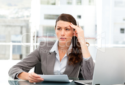 Serious female executive finding ideas while working at her desk