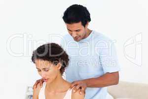 Hispanic man doing a massage to his beautiful wife