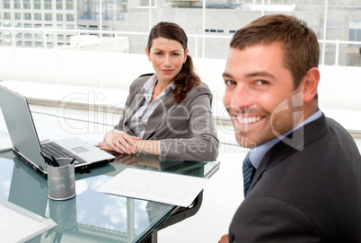 Happy businessman and businesswoman working together on a laptop