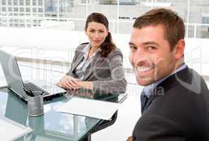 Happy businessman and businesswoman working together on a laptop