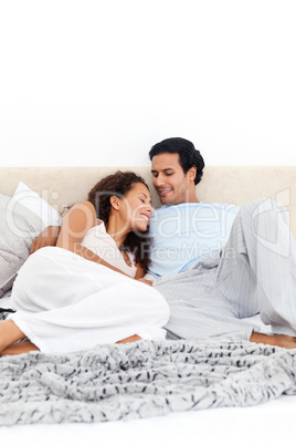 Passionate couple lying together on their bed