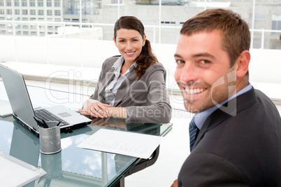 Happy businesspeople working together on a laptop during a meeti