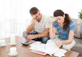 Worried couple doing their accounts in the living room