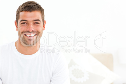Cheerful man stting on his bed at home