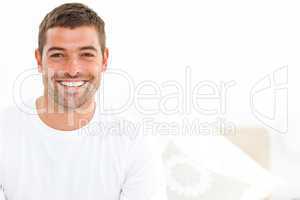 Cheerful man stting on his bed at home