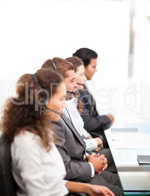 Four businesspeople on the phone sitting at their desk