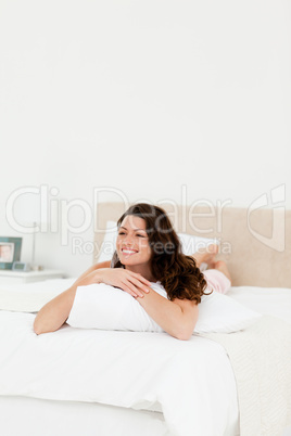 Pretty woman relaxing at home lying on her bed