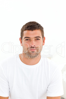 Portrait of a serious man sitting on his bed