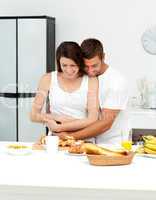 Happy couple hugging while preparing their breakfast together