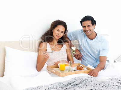 Pretty woman eating cereals for breakfast lying on her bed
