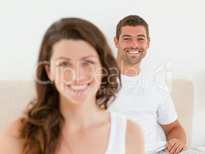 Happy man lying on his bed with his girlfriend