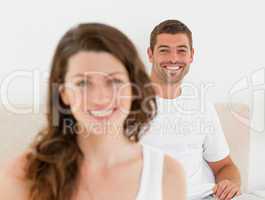 Happy man lying on his bed with his girlfriend