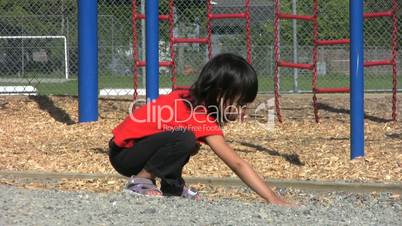 Little Girl Playing With Stones At Playground