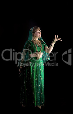 young girl in indian costume look at light