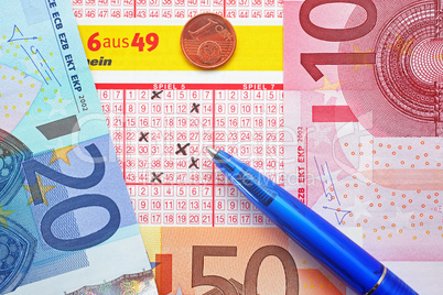 Lottoschein mit Euros und Kugelschreiber