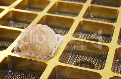 Weisse Praline in goldener Box
