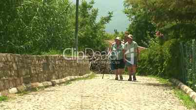 Elderly married couple walking on cobbled road 1