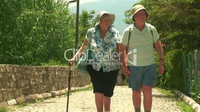 Elderly married couple walking on cobbled road 2